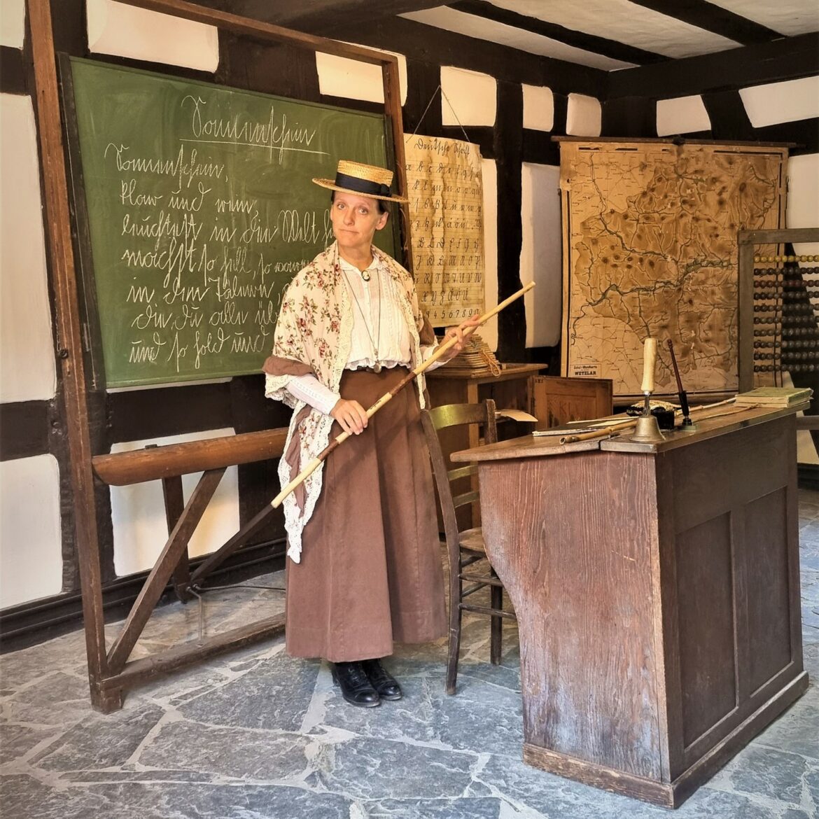 Historisch gekleidete Lehrerin in der Schule aus Frickhofen