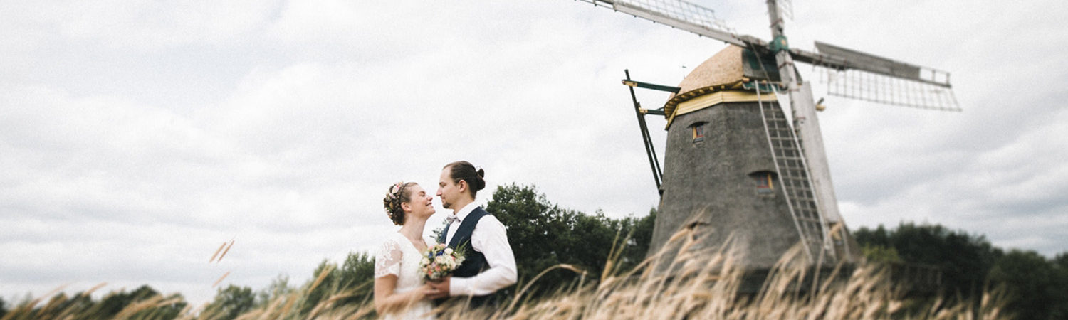 Hochzeitspaar im Feld vor der Windmühle Borsfleth